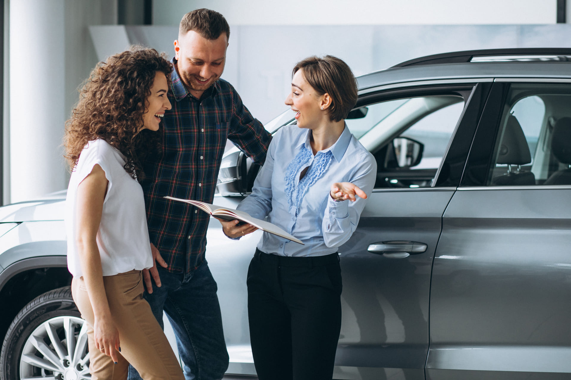 young-couple-talking-with-salesman-in-a-car-showroom car rental in Aruba prices